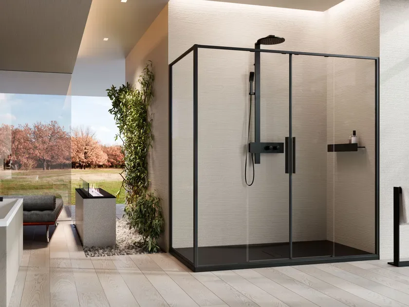 Black-framed glass shower cubicle in a light tiled bathroom